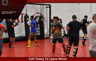 Students training martial arts indoors at Arizona Combat Sports during Arizona summer heat