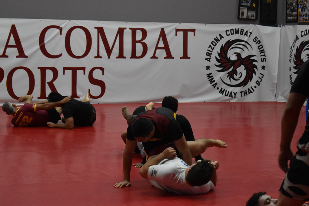 Two students drilling Brazilian Jiu Jitsu technique on the mat at Arizona Combat Sports in the East Valley, book your trial class today